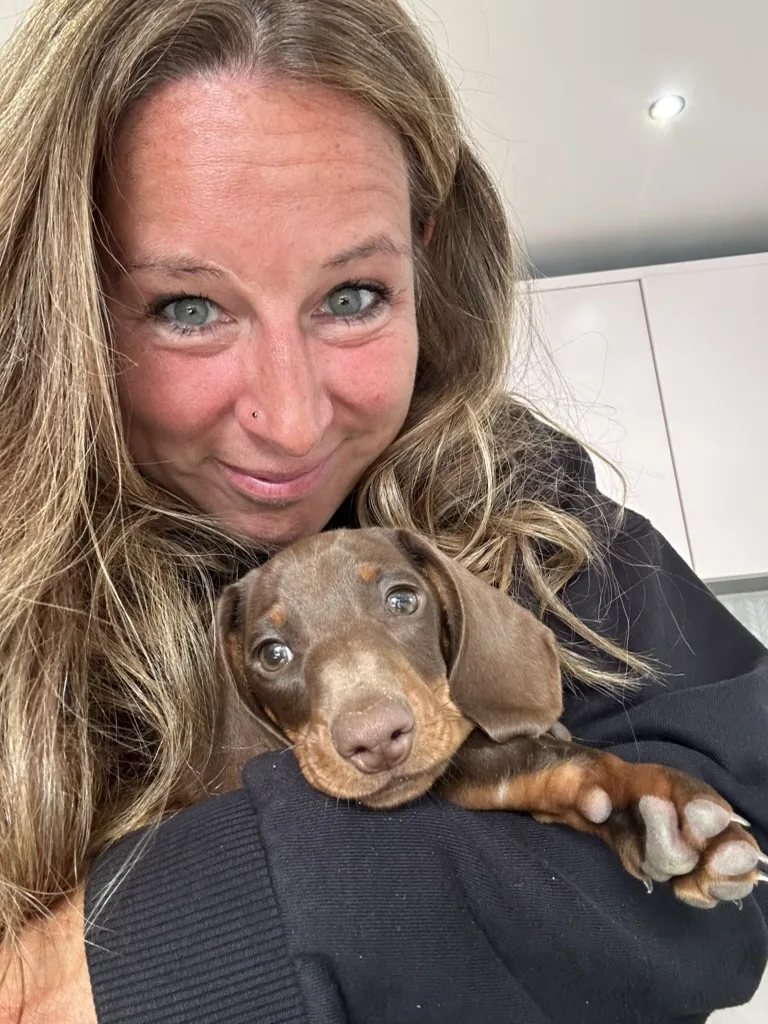 Francesca smiling while holding her puppy