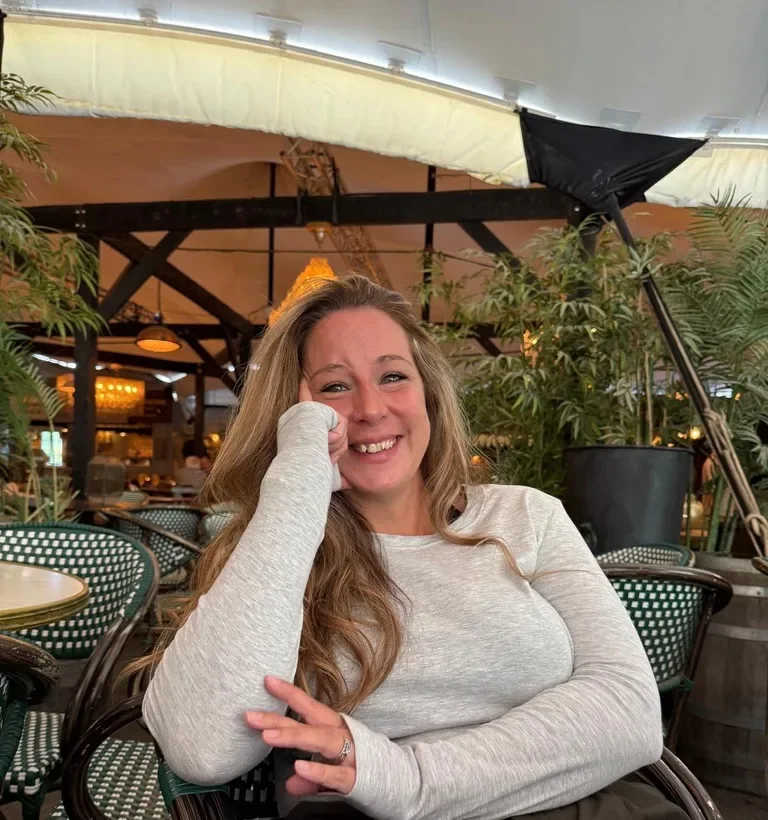 Francesca smiling while sitting at a café