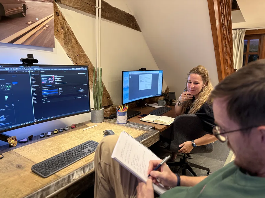 Francesca at her desk with a colleague taking notes